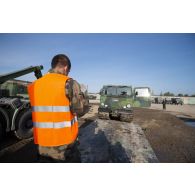 Un soldat guide le chargement d'un véhicule articulé chenillé (VAC) Bandvagn 206 à bord d'un camion porteur polyvalent logistique (PPLOG) à Jõhvi, en Estonie.