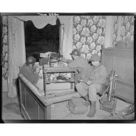 Soldats veillant à leur poste de guet, armés d'une mitrailleuse M1919 A4 en position à la fenêtre d'une maison et d'un mortier de 60 mm.