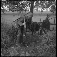 Les servants d'une mitrailleuse Hotchkiss modèle 1914 du 310e régiment d'infanterie (RI) progressent lors d'un exercice. Ils sont équipés de fusils 07/15 modèle 1916.