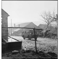 Un véhicule blindé léger faisant partie de la 2e DIM traverse le village de Courchaton.