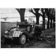 Epave d'un half-track M3 sur une route.