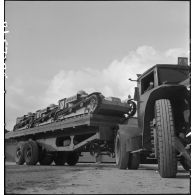 Plan général de chenillettes de ravitaillement Renault 31R transportées sur une remorque porte-chars à la sortie des ateliers de fabrication d'Issy-les-Moulineaux.