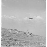 Un avion de reconnaissance, Potez série 63, survole un canon antiaérien de 90 mm, appartenant à la 4e batterie de 90 mm CA.