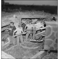 Des marins, appartenant à la 4e batterie mobile de défense antiaérienne de la Marine, chargent un canon antiaérien de 90 mm CA.