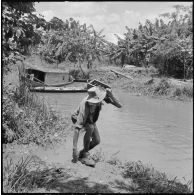 Un sergent du 43e régiment d’infanterie colonial (43e RIC) rapporte des grenades Viêt-minh récupérées lors de la fouille du rach.