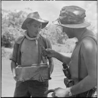 Un sergent du 43e régiment d’infanterie colonial (43e RIC) rapporte des grenades Viêt-minh récupérées lors de la fouille du rach.