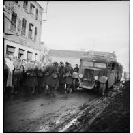 Plan général de permissionnaires de la 2e armée qui attendent au bord d'une rue.