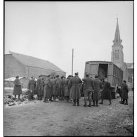 Des soldats de la 2e armée, portant des pelles et des pioches, sont rassemblés.