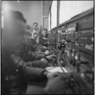 Des soldats utilisent des appareils de transmissionss dans un central téléphonique.