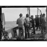 Baie de Bizerte. Le dragueur de mines La Charrue, mise à l'eau des flotteurs remorquant les cisailles. [légende d'origine]