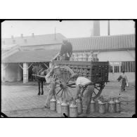 Parc de l'usine de produits chimiques de Croissy. Le lait est chargé en voiture pour être vendu au commerce. [légende d'origine]