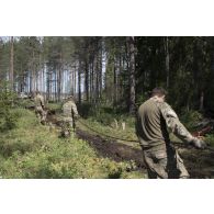 Des soldats britanniques déroulent un câble pour dépanner un véhicule blindé d'infanterie britannique à Tapa, en Estonie.