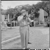 Le général Erskine, membre de la mission militaire américaine, prend une photographie au cours d'une prise d'armes à Haïphong.