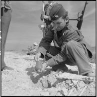 Déterrement d'une mine antipersonnel de fabrication artisanale par un sergent-chef du génie sur la route coloniale n°1 au Tonkin.