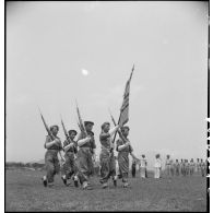 Défilé du drapeau du 7e bataillon vietnamien (7e BVN) et sa garde devant le général de Lattre de Tassigny et Tran Van Huu sur le terrain d'aviation de Vinh Yen.