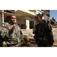 Patrouille à pied dans le village d'At Tiri par un groupe de la 3e compagnie du RMT (régiment de marche du Tchad), appartenant au détachement français de la FINUL (Force intérimaire des Nations unies au Liban). Discussion avec un militaire libanais devant des bâtiments en ruines portant des impacts de tirs.