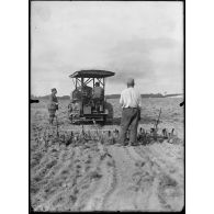 Versailles-Trianon (Seine-et-Oise). Pépinières nationales de plants de légumes. Tracteur avec train de herse canadienne. [légende d'origine]