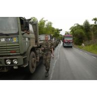 Le trafic local continue le long du convoi à l'arrêt.