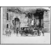 [Un groupe de soldats devant un bâtiment en ruines.]