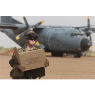 Un soldat du 1er régiment de chasseurs parachutistes (1er RCP) transporte des rations de combat sur l'aéroport de Gao, au Mali.