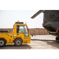 Un tracteur d'avions britannique tracte un hélicoptère Chinook ch-47 hors de son hangar à Gao, au Mali.