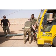 Des soldats britanniques détachent un hélicoptère Chinook Ch-47 d'un tracteur d'avions après sa sortie de hangar à Gao, au Mali.