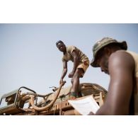 Le caporal-chef Mohamed communique la liste des citernes d'eau que son waterboy doit remplir dans la matinée à Gao, au Mali.