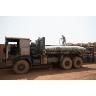 Le caporal-chef Mohamed remplit une citerne d'eau au moyen d'un bac souple chargé sur la plateforme de son camion TRM-10000 à Gao, au Mali.