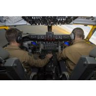 Des pilotes manoeuvrent à bord du cockpit de leur avion Boeing C-135 FR en vol au-dessus du Mali.