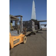 Un personnel du détachement de transit interarmées (DéTIA) décharge du fret depuis la soute d'un avion Super Hercules C-130J de l'armée de l'air canadienne à Gao, au Mali.