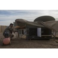 Un soldat entretient une antenne satellitaire sur le camp de Ménaka, au Mali.