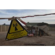 Un soldat entretient une antenne satellitaire sur le camp de Ménaka, au Mali.