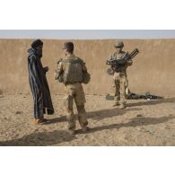 Des soldats contrôlent un habitant venu pour une consultation médicale à In Arabane, au Mali.