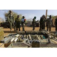 Des soldats maliens disposent de l'armement trouvé dans une cache d'armes pour une présentation à la presse à Gao, au Mali.