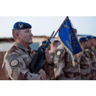 Le porte-drapeau du 5e régiment d'hélicoptères de combat (RHC) présente les armes du groupement tactique désert Homobri à Gao, au Mali.