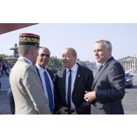 Le général Benoît Puga échange avec le Premier ministre Jean-Marc Ayrault aux côtés du ministre de la Défense Jean-Yves Le Drian et son délégué aux Anciens combattants Kader Arif sur la place de la Concorde, à Paris.