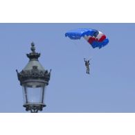 Un parachutiste de l'Ecole des troupes aéroportées de Pau (ETAP) saute au-dessus de la place de la Concorde, à Paris.