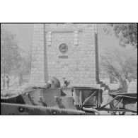 Une chenillette d'infanterie passe devant le monument commémoratif dédié au colonel Monteil à Niamey.