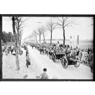 Sur une route, les troupes polonaises (75 mm M1897 hippomobile) défilent devant les officiels civils et militaires, polonais et français.