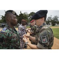 Un instructeur du 13e bataillon de chasseurs alpins (BCA) remet un insigne de moniteur à un gendarme ivoirien à l'issu de sa formation à Abidjan, en Côte d'Ivoire.