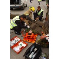 Triage des blessés selon les priorités d'urgence et premiers soins par les pompiers de l'aéroport et les médecins locaux avant évacuation. Civière d'immobilisation.