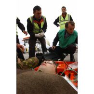 Triage des blessés selon les priorités d'urgence et premiers soins par les pompiers de l'aéroport et les médecins locaux avant évacuation.