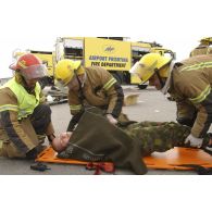 Triage des blessés selon les priorités d'urgence et premiers soins par les pompiers de l'aéroport et les médecins locaux avant évacuation.