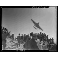 Démonstration du vol d'un avion militaire sous le regard de militaires et de civils algériens dans la région de Tebessa.