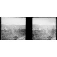 [Une femme observe un village depuis le bord d'un chemin].