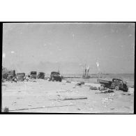 Rhe Feldy. [Camions abandonnés sur une plage]. [Description en cours]