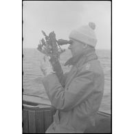 A bord d'un dragueur de mines de la classe 1940, un capitaine (Kapitänleutnant) utilise un sextant.