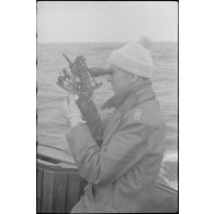 A bord d'un dragueur de mines de la classe 1940, un capitaine (Kapitänleutnant) utilise un sextant.