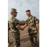 Le général de brigade Pierre Gillet, commandant la force Sangaris, remet la médaille militaire à un adjudant, lors du rassemblement des troupes composant le PCIAT (poste de commandement interarmées de théâtre) dans le cadre de la commémoration du 8 mai 1945.