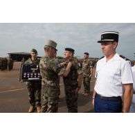 Le général de brigade Pierre Gillet, commandant la force Sangaris, remet la médaille militaire à un adjudant, lors du rassemblement des troupes composant le PCIAT (poste de commandement interarmées de théâtre) dans le cadre de la commémoration du 8 mai 1945.